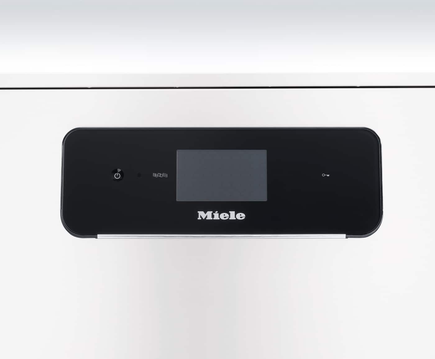 Nærbilde av Mieles betjeningspanel med svart glassfront, et lite display i midten og en tast til venstre.