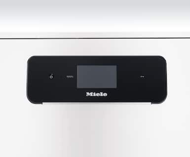 Nærbilde av Mieles betjeningspanel med svart glassfront, et lite display i midten og en tast til venstre.
